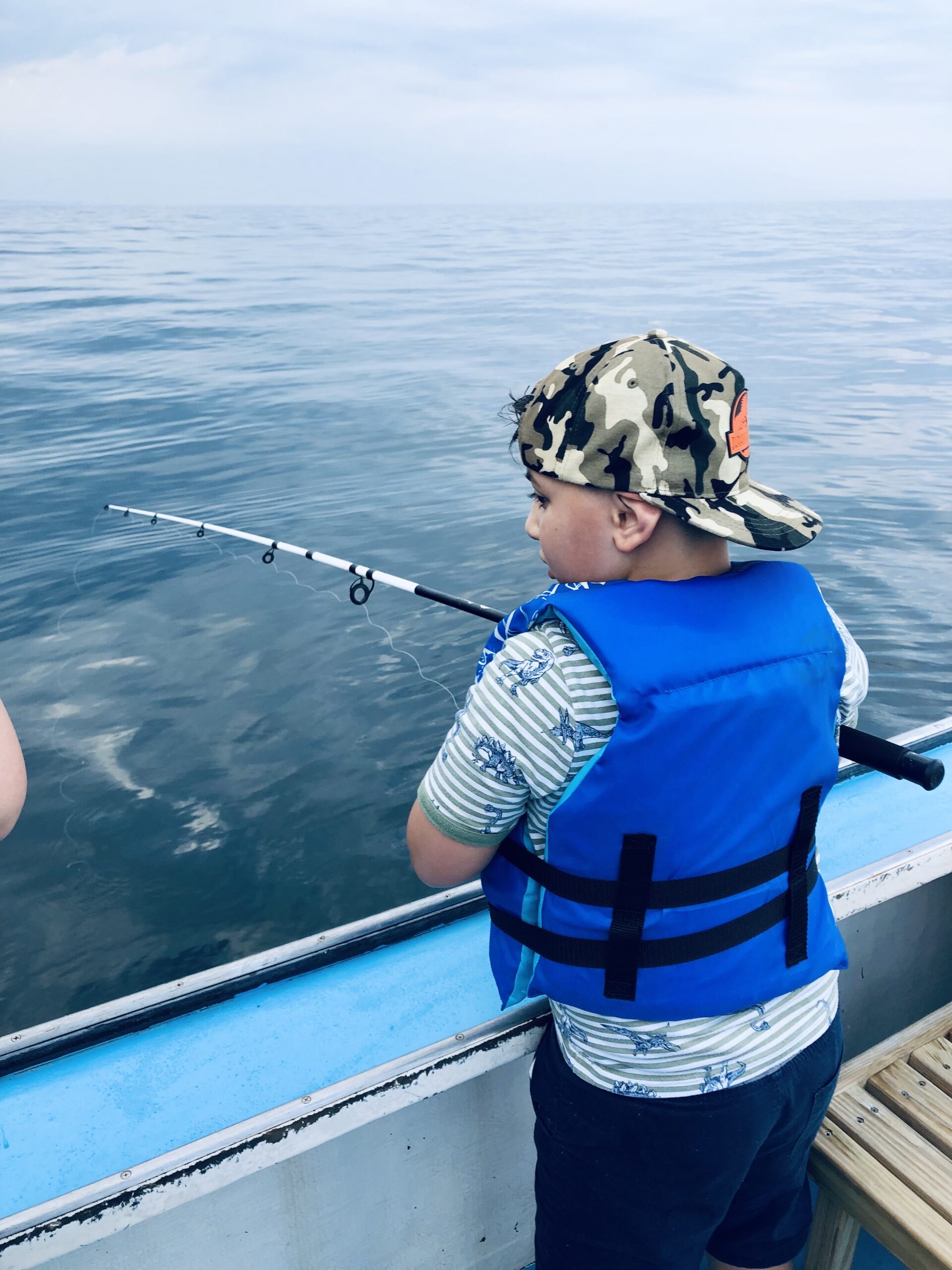 young-boy-wearing-a-life-jacket-fishing-2026-01-06-11-08-27-utc